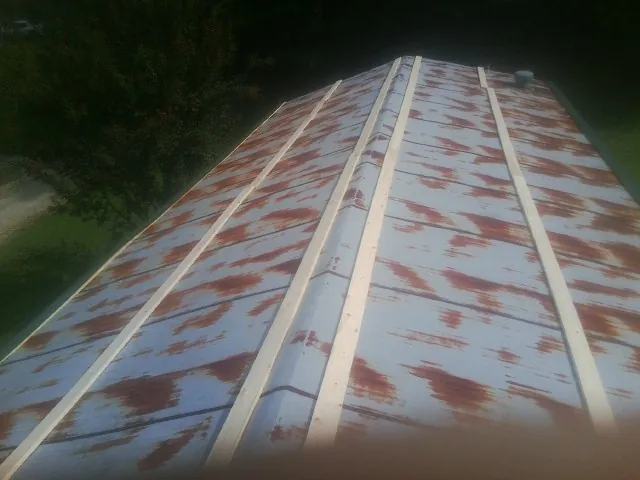 Rusted metal roof panels with new wood purlins before replacement — Storm Damage Roof Repair in Felda by Roofing Brothers